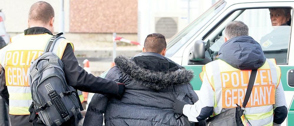 Polizisten begleiten einen Asylbewerber zu seinem Abflug.