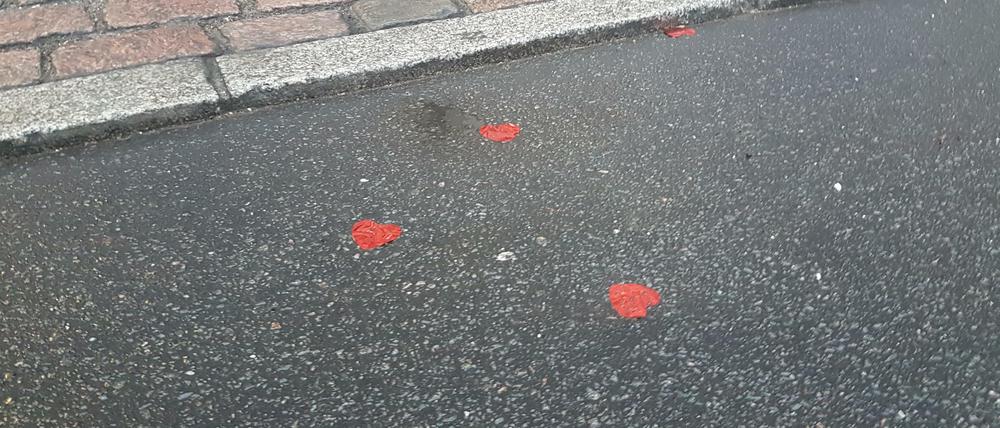 Lauter rote Herzchen liegen vor dem Tagesspiegel auf der Straße. Wo kommen sie her?