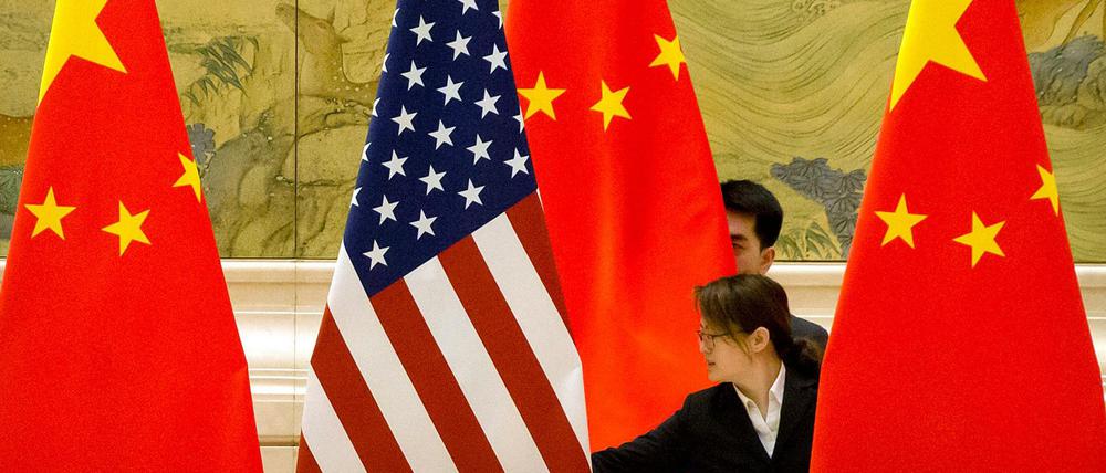 Alte und neue Supermacht: Chinesische Mitarbeiter richten im Rahmen von Handelsgesprächen zwischen China und den USA Flaggen aus. 