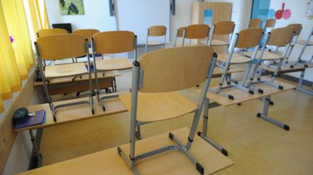 In einem Klassenzimmer sind die Stühle auf die Tische gestellt.