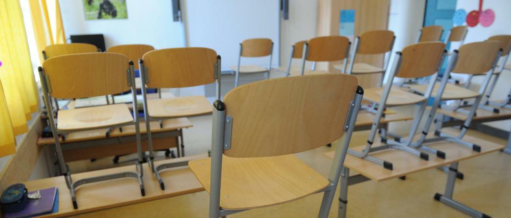 In einem Klassenzimmer sind die Stühle auf die Tische gestellt.