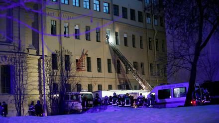 Ein Feuerwehrmann steigt durch ein Fenster eines Universitätsgebäudes in St. Petersburg. 