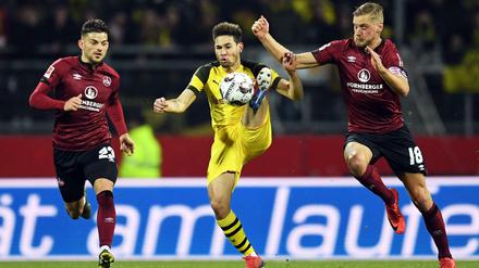 Hoch das Bein. Dortmunds Raphael Guerreiro wird von den beiden Nürnbergern Hanno Behrens (r.) und Tim Leibold bedrängt. 