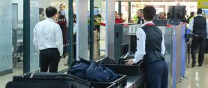 Passagiere und ihr Handgepäck werden bei einer Sicherheitskontrolle im Flughafen Tegel kontrolliert. 