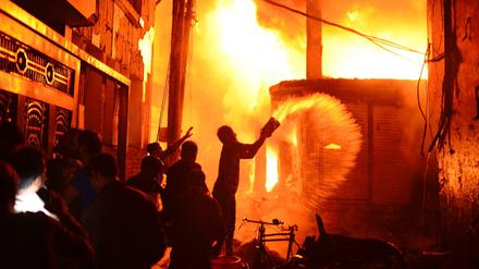 Feuerwehr und Anwohner versuchen den Brand zu löschen.