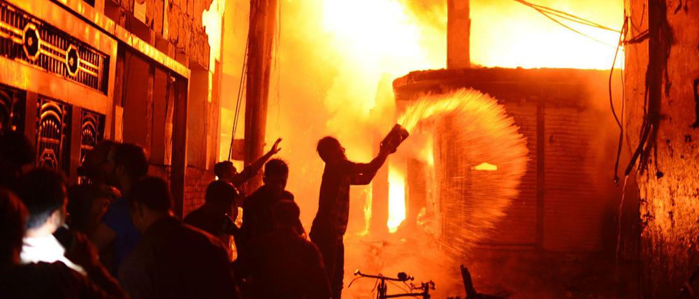 Feuerwehr und Anwohner versuchen den Brand zu löschen.