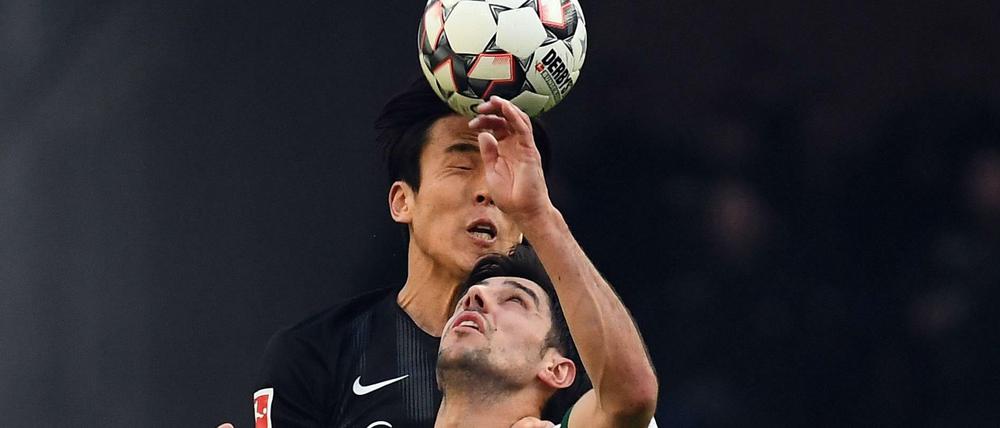 Kopf, Kopf, Ball. Frankfurts Makoto Hasebe (oben) und Lars Stindl.