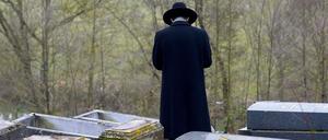 Ein Rabbi steht auf einem jüdischen Friedhof in Frankreich.