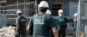 Zollbeamte betreten bei einer Razzia gegen Schwarzarbeit eine Baustelle. 