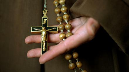 Kruzifix und Rosenkranz in der Hand einer Novizin 