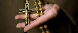 Kruzifix und Rosenkranz in der Hand einer Novizin 