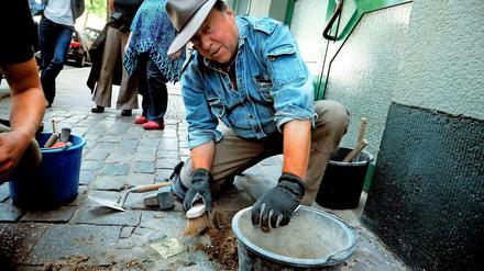 Der Künstler Gunter Demnig verlegt Stolpersteine in Berlin.