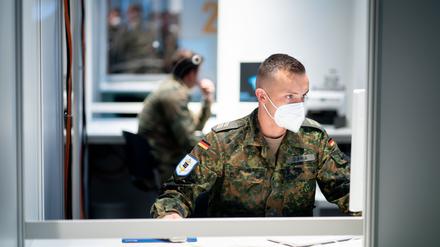 Ein Bundeswehrsoldat arbeitet beim Testlauf im Berliner Corona-Impfzentrum in Treptow in der Anmeldungsstation.