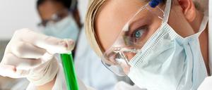 Eine Nachwuchsforscherin und ein Kollege untersuchen Proben in einem Labor.