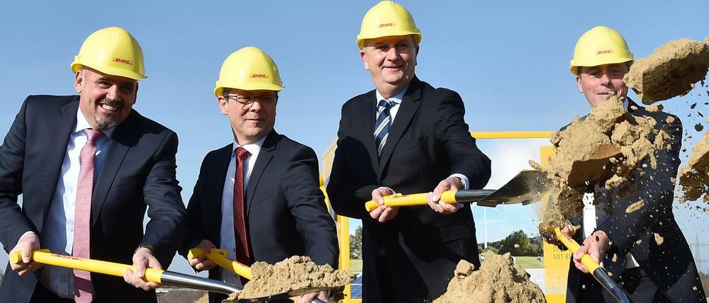 Ralf Steffes (l-r), Geschäftsbereichsleiter Infrastruktur Betrieb Post & Paket Deutschland, Andreas Igel, Bürgermeister Ludwigsfelde, Dietmar Woidke (SPD), Ministerpräsident Brandenburgs, und Dietmar Büdenbender, Deutsche Post DHL Group, Executive Vice President Corporate Real Estate.