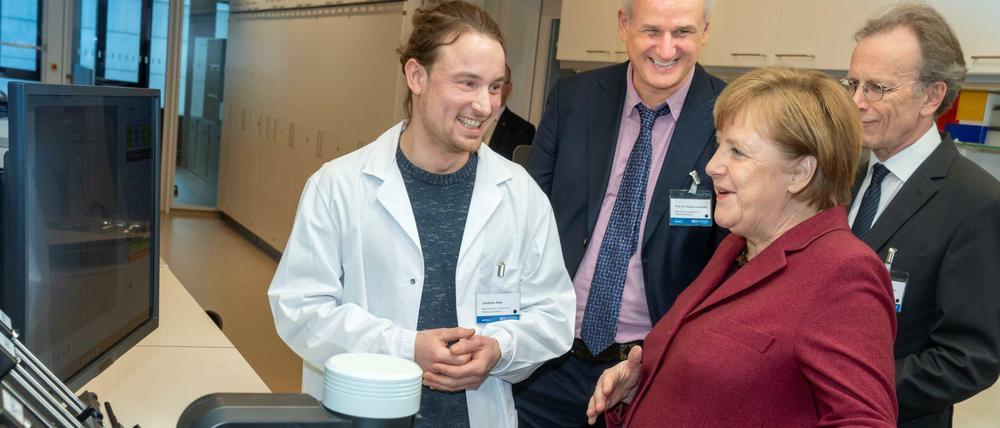 Jonathan Alles, Doktorand am BIMSB, Forschungsleiter Nikolaus Rajewsky und MDC-Vorstand Martin Lohse (vlnr) präsentieren Bundeskanzlerin Angela Merkel die Apparatur, mit der das Erbgut von Millionen von Zellen eines Organs Zelle für Zelle untersucht werden kann.