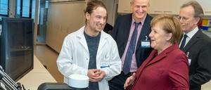 Jonathan Alles, Doktorand am BIMSB, Forschungsleiter Nikolaus Rajewsky und MDC-Vorstand Martin Lohse (vlnr) präsentieren Bundeskanzlerin Angela Merkel die Apparatur, mit der das Erbgut von Millionen von Zellen eines Organs Zelle für Zelle untersucht werden kann.