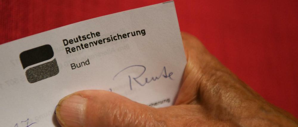 Eine ältere Frau hält ihren Rentenbescheid in der Hand (gestellte Szene).