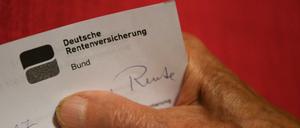 Eine ältere Frau hält ihren Rentenbescheid in der Hand (gestellte Szene).