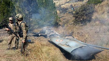 Pakistanische Soldaten stehen neben dem Wrack eines abgestürzten Flugzeugs.