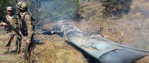 Pakistanische Soldaten stehen neben dem Wrack eines abgestürzten Flugzeugs.