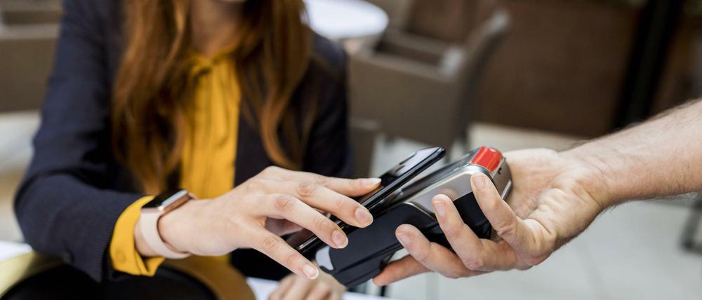 Wer mit dem Smartphone zahlen will, braucht es nur kurz ans Kartenlesegerät halten.