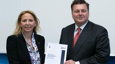 Polizeipräsidentin Barbara Slowik und Innensenator Andreas Geisel (SPD) halten die polizeiliche Kriminalstatistik 2018 in den Händen. 