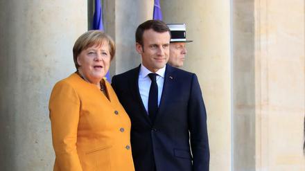 Der französische Präsident Emmanuel Macron begrüßt die deutsche Kanzlerin Angela Merkel in Paris.