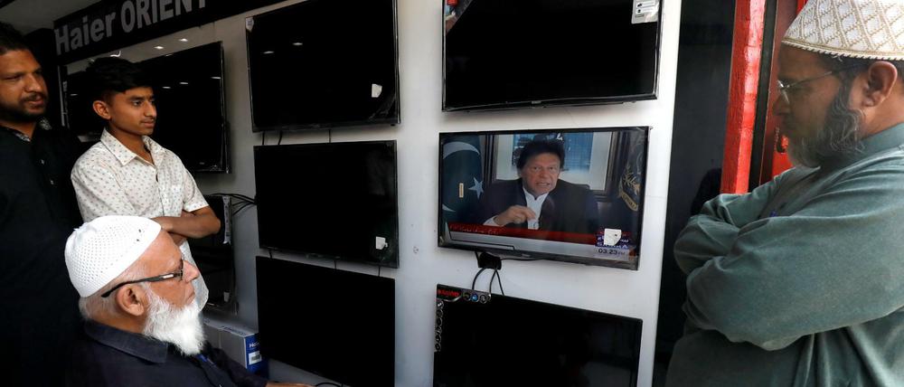 Großes Interesse: Ladeninhaber in Karachi verfolgen die Rede des pakistanischen Regierungschefs Imran Khan. 