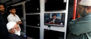 Großes Interesse: Ladeninhaber in Karachi verfolgen die Rede des pakistanischen Regierungschefs Imran Khan. 