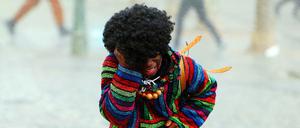 Narren flüchten am Rosenmontag 2016 in Düsseldorf vor Regen und Sturm.