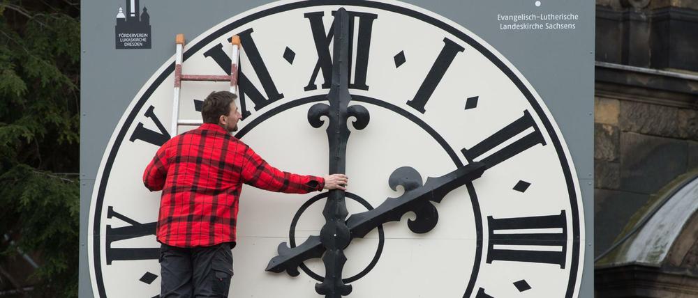 Ein Uhrentechniker kontrolliert die Mechanik der Zeiger der Kirchturmuhr der Dresdner Lukaskirche.