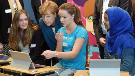 Bundeskanzlerin Angela Merkel spricht mit zwei Schülerinnen über das Programmieren