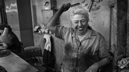 Eine Arbeiterin im VEB Elektrokohle will sich noch schnell die Haare schick machen.