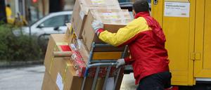 Ein Paketbote von DHL liefert Päckchen aus.
