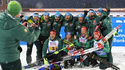 Arnd Peiffer, Vanessa Hinz, Denise Herrmann und Benedikt Doll (vorne von links nach rechts) posieren mit Teamkameraden nach der Siegerehrung. 