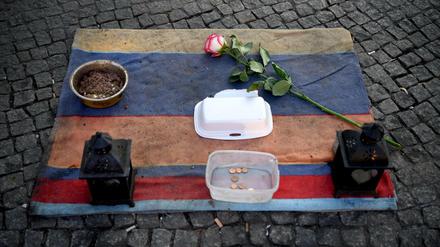 Ein paar Habseligkeiten der Obdachlosen und eine Rose liegen auf einer Decke am Cajamarcaplatz am S-Bahnhof Schöneweide.