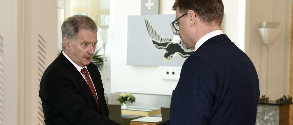 Sauli Niinistö (l), Präsident von Finnland, gibt Juha Sipilä, Ministerpräsident von Finnland, bei einem Treffen die Hand.