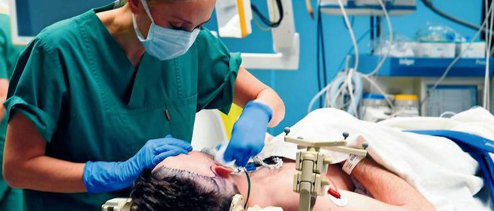 OP-Vorbereitung: Der Kopf des Patienten ist fixiert und das Operationsgebiet markiert. Er ist bei Bewusstsein. 