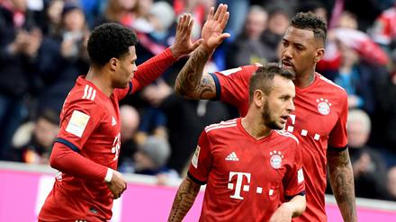 Die Spieler (l-r) Serge Gnabry, Rafinha und Jerome Boateng vom FC Bayern jubelt nach dem 1:0 gegen den VfL Wolfsburg durch Gnabry.