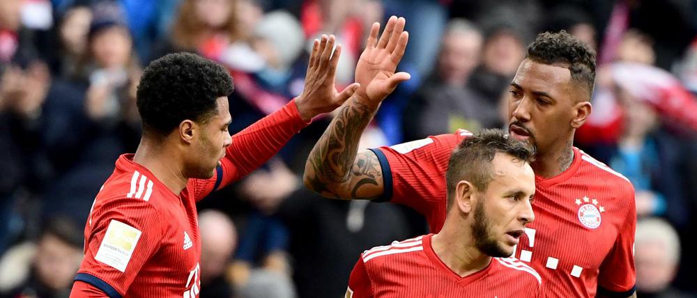 Die Spieler (l-r) Serge Gnabry, Rafinha und Jerome Boateng vom FC Bayern jubelt nach dem 1:0 gegen den VfL Wolfsburg durch Gnabry.