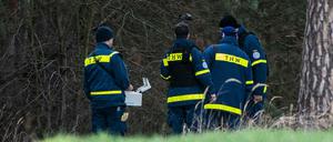 Mitglieder einer Spezialgruppe des Technischen Hilfswerks stehen mit einem Bodenradargerät in einem Wald bei Storkow.