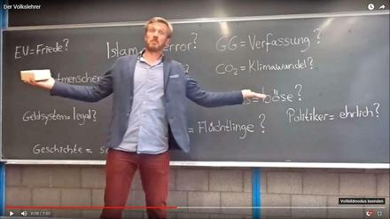 Im Internet posiert der „Volkslehrer“ gerne vor einer Tafel mit Verschwörungstheorien. Jetzt will er in die Politik. 