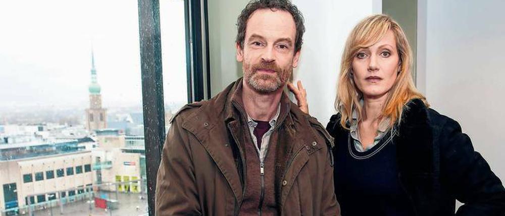 Die Schauspieler Jörg Hartmann (spielt Kommissar Peter Faber) Anna Schudt als Martina Bönisch, stehen während der Dreharbeiten der ARD-Krimireihe "Tatort" an einem Fenster mit Blick auf den Hansaplatz und die Reinoldikirche in Dortmund.
