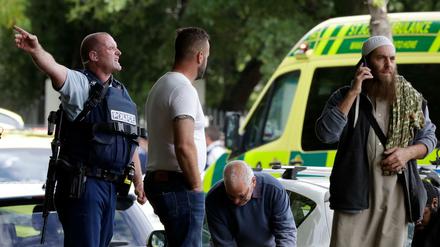 Ein Polizist versucht den Bereich nahe eines der Tatorte des Terroranschlags in Christchurch zu räumen.