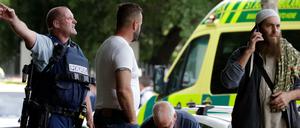 Ein Polizist versucht den Bereich nahe eines der Tatorte des Terroranschlags in Christchurch zu räumen.