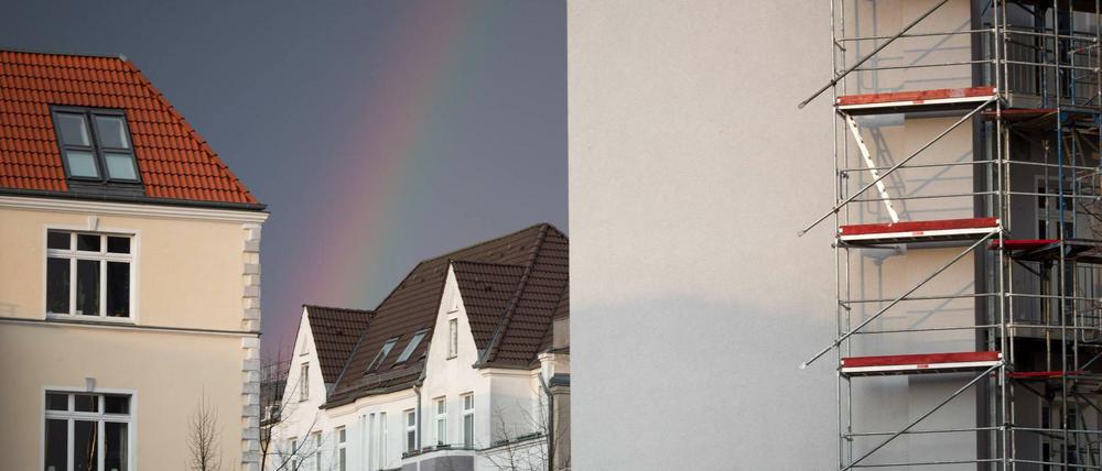 Altbau Regenbogen über Altbau in Berlin Friedrichshain. Im Vordergrund wird ein Gebäude saniert.