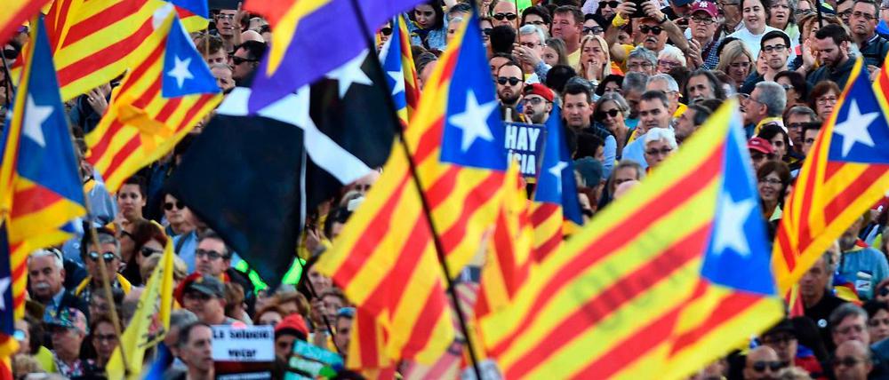 Menschen schwenken die katalanische Flagge bei einer Demonstration in Madrid.