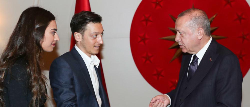 Dieses vom Presidential Press Service am 17.03.2019 zur Verfügung gestellte Foto zeigt Recep Tayyip Erdogan (r), Staatspräsident der Türkei, der nach Angaben des türkischen Präsidialamtes eine Einladungskarte für die Hochzeit des türkisch-deutschen Ex-Nationalspieler Mesut Özil (M) und seiner Verlobten Amine Gulse in Istanbul entgegen nimmt. 