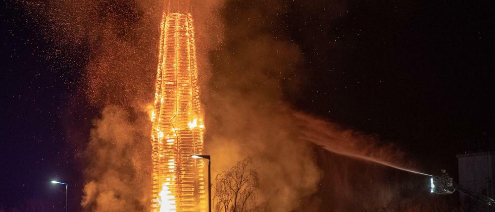 Ein 60 Meter hohe Holzturm wird von der Feuerwehr wegen starkem Funkenflug gelöscht.